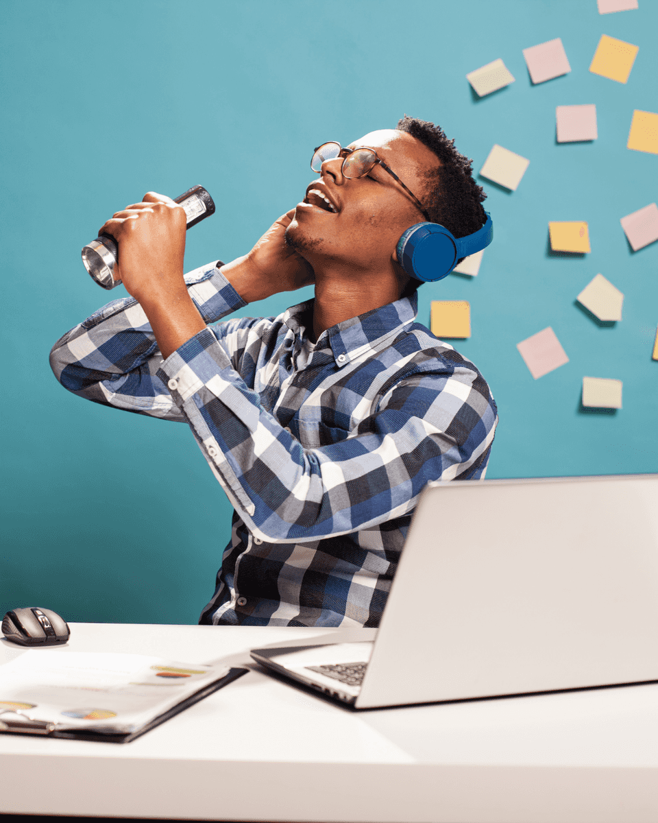 Man singing into a microphone at his desk