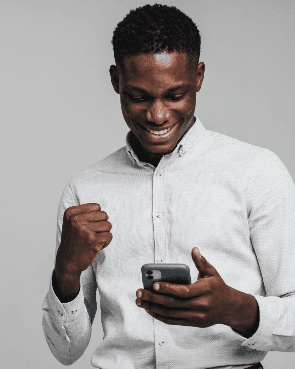 Man celebrating while looking at his phone