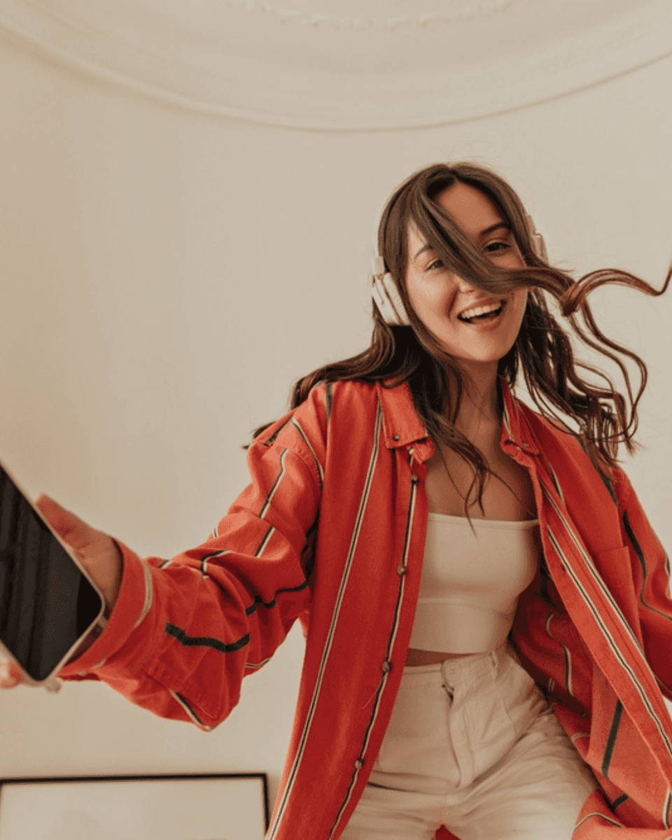 Woman in an orange jacket recording a video