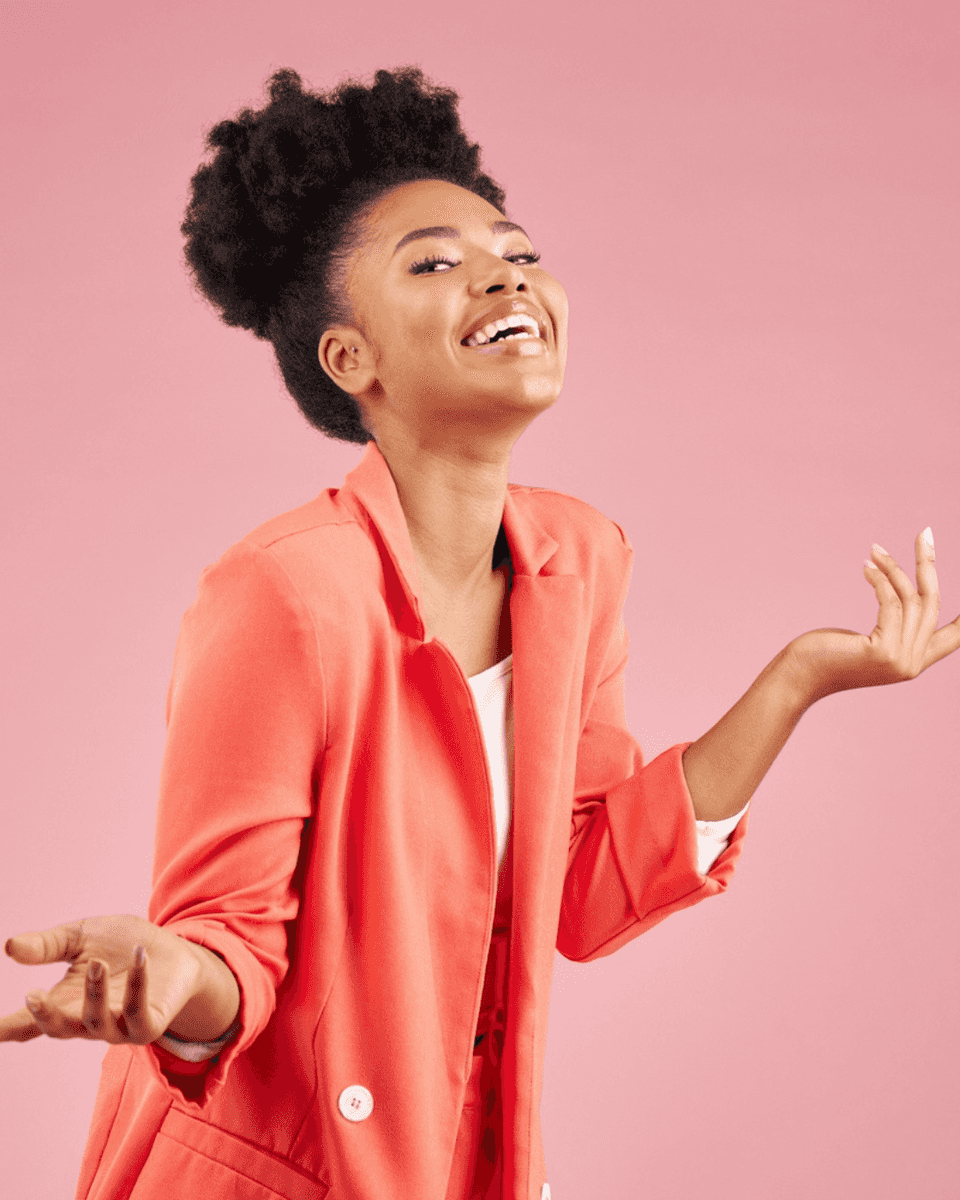 Woman in a coral blazer laughing